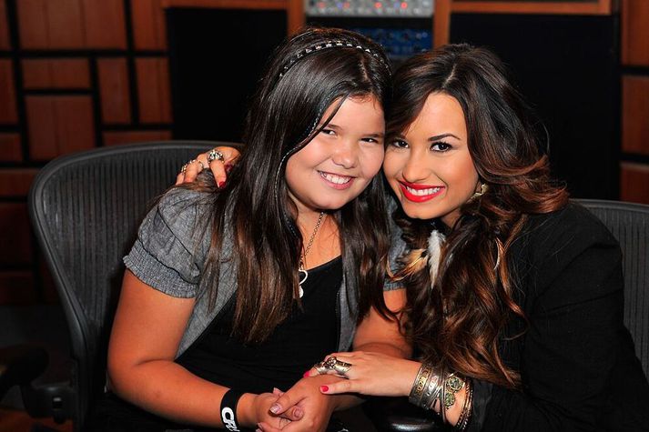 Madison de la Garza með söngkonunni Demi Lovato á tónleikum þeirrar síðarnefndu árið 2011. Þær eru hálfsystur.