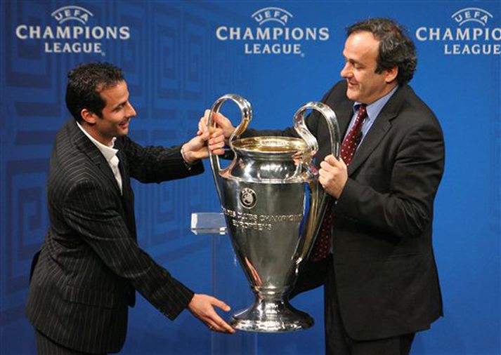 Ludovic Giuly, leikmaður Barcelona, afhendir landa sínum Michel Platini, forseta UEFA, Meistaradeildarbikarinn í Aþenu í dag en Barcelona mun ekki verja titil sinn þar sem liðið féll úr leik í 16 liða úrslitum gegn Liverpool.