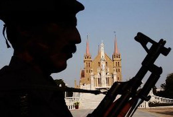 Pakistanskur lögreglumaður stendur vörð við kirkju í Pakistan í dag.