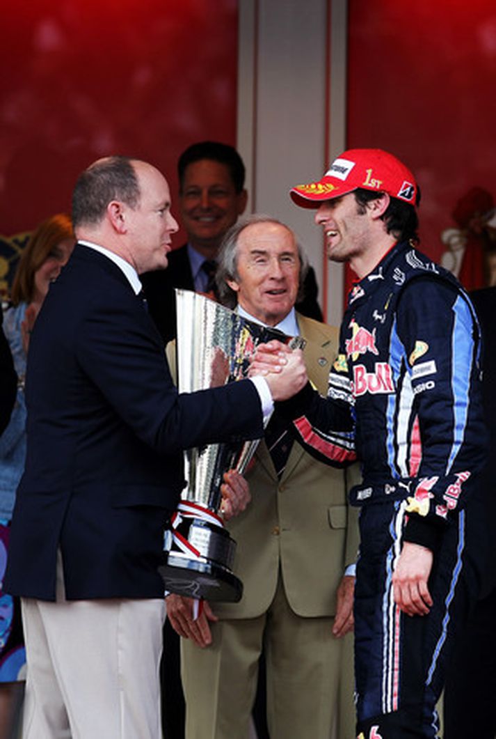 Prins Albert afhendir mark Webber sigurlaunin í Mónakó, en Jackie Stewart fyrrum Formúlu 1 kappi fylgist með.