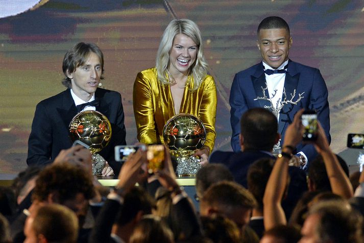 Ada Hegerberg fagnar verðlaunum sínum við hlið Luka Modric og Kylian Mbappe.