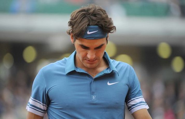Roger Federer gengur niðurlútur af velli í dag.
