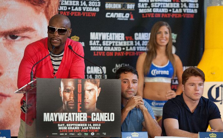 Mayweather stendur og talar en De la Hoya situr við hlið hans.