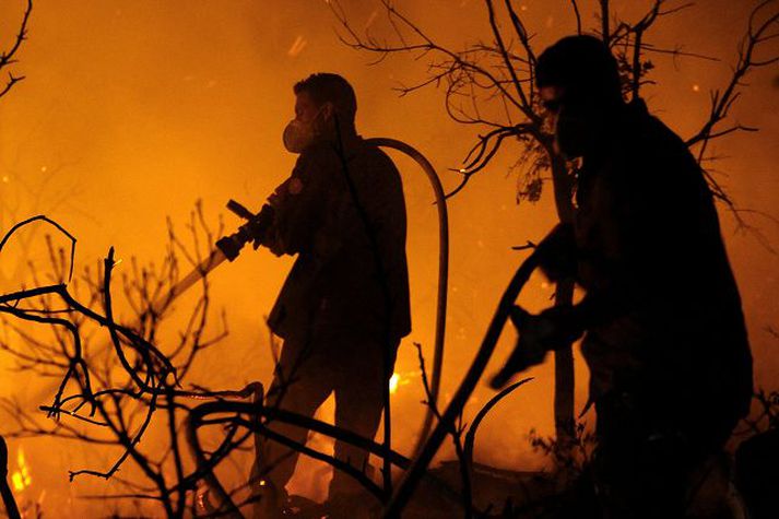 Barist við eldana Slökkviliðið átti litla möguleika á að ráða við ofsa eldanna.
nordicphotos/AFP