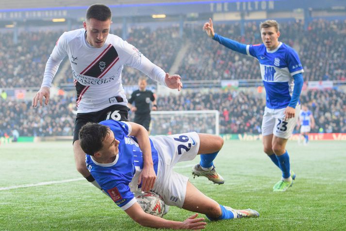 Alfons Sampsted fylgist hér með þegar Dom Jefferies hjá Lincoln City og Luke Harris hjá Birmingham City berjast um boltann í leiknum í dag.