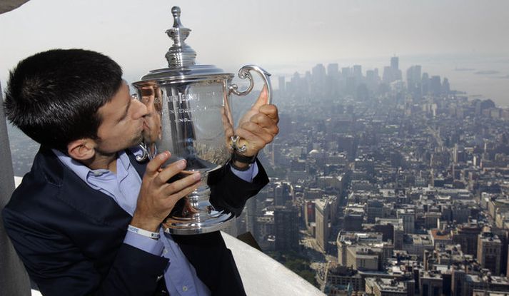 Novak Djokovic kyssir bikarinn á efstu hæð í Empire State byggingunni.