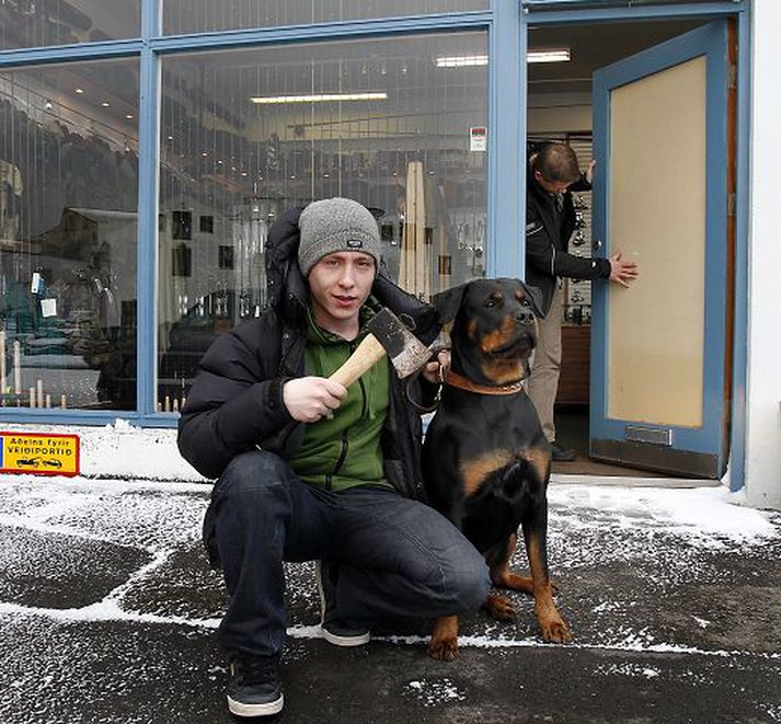 Lúðvík Kjartan Kristjánsson og tíkin París náðu innbrotsþjófi sem reyndi að komast undan úr Veiðiportinu. Tómas Skúlason, eigandi verslunarinnar, hugar að skemmdum á hurðinni. Fréttablaðið/GVA