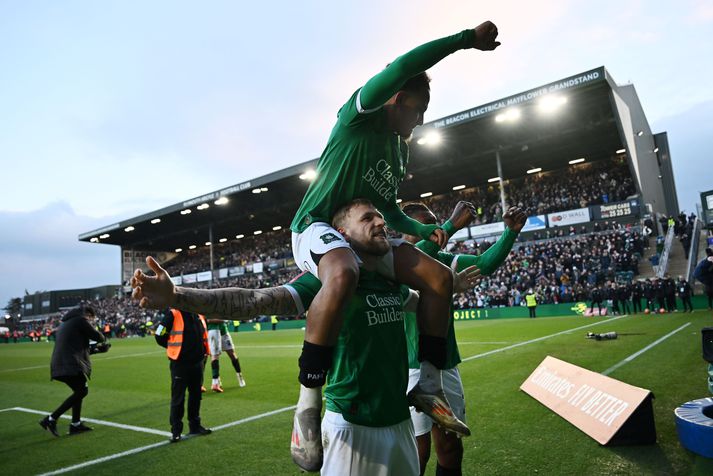 Lewis Gibson, Matthew Sorinola og Muhamed Tijani fagna sigri Plymouth Argyle á Liverpool.