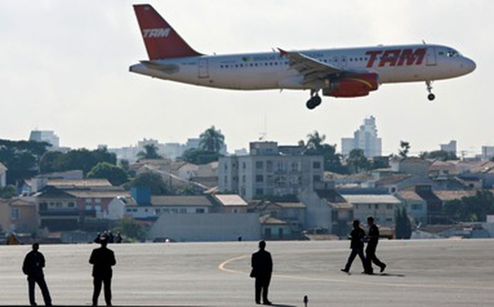 Flugvallarstarfsmenn skoða flugbrautina á Conghas flugvellinum í Sao Paulo í kjölfar flugslyssins.