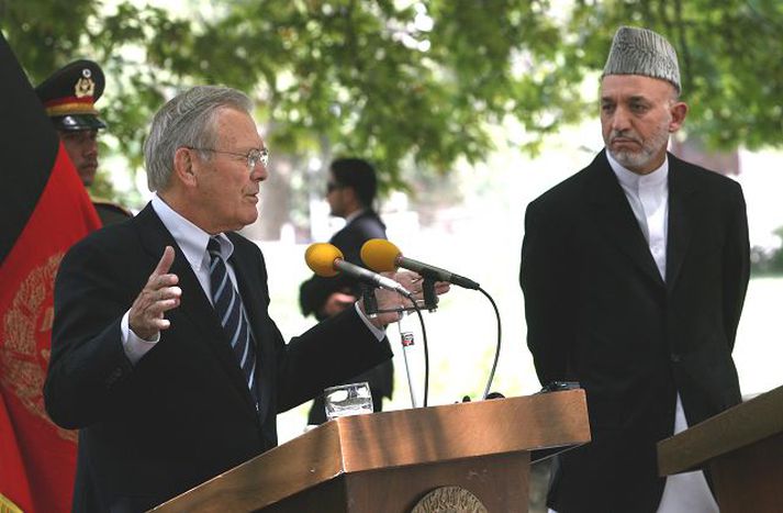 Hamid Karzai fylgist grannt með þegar Rumsfeld útskýrir málin.