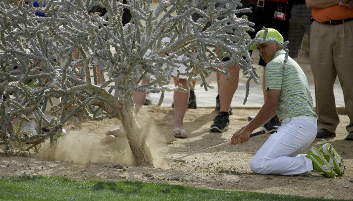 Rickie Fowler slær úr erfiðri stöðu í dag.