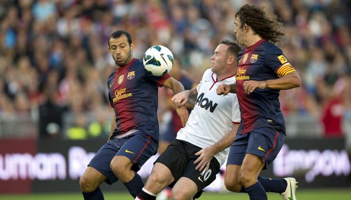 Rooney í baráttu við Puyol og Mascherano í kvöld.