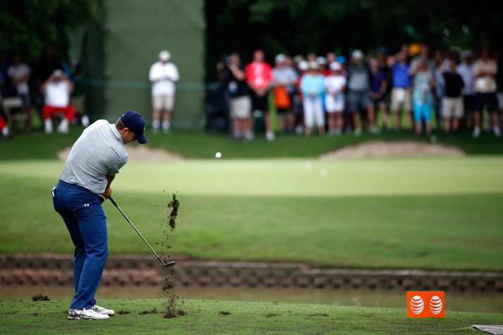 Jordan Spieth tekur upphafshögg á 14. holu sem stytt var vegna rigningar.