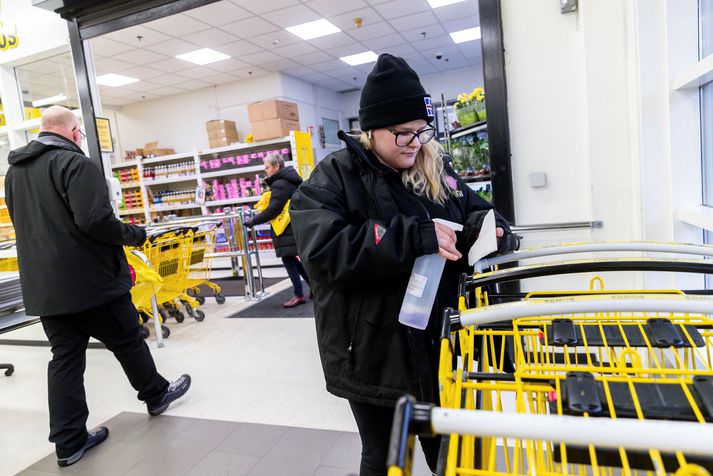 Starfsmaður Bónus sótthreinsar innkaupakerrur fyrr í faraldrinum. Útlit er fyrir að sóttvarnaaðgerðir gætu verið hertar aftur fljótlega vegna fjölgunar smita í samfélaginu.