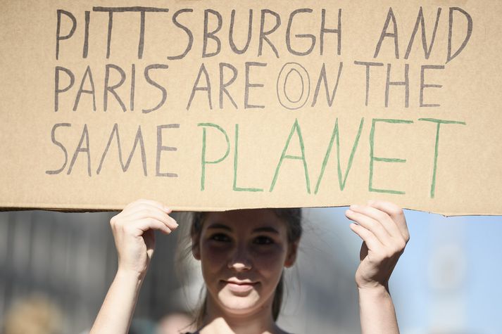 Trump sagðist vinna fyrir Pittsburgh en ekki París. Mótmælandi bendir honum á að báðar borgir séu á plánetunni jörð.