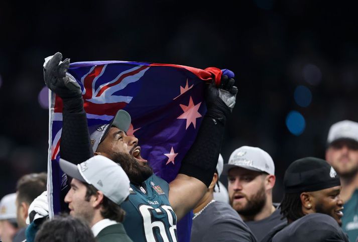 Jordan Mailata er fyrsti Ástralinn sem fagnar sigri í Super Bowl. Hann fagnar hér með fána sinnar þjóðar eftir leikinn.