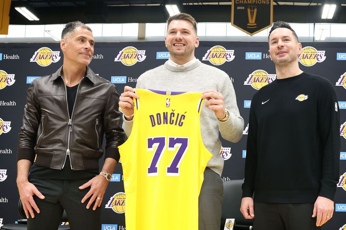 Luka Doncic með treyju sína við hlið framkvæmdastjórans Rob Pelinka og þjálfarans JJ Redick.