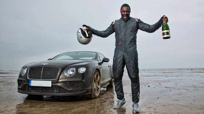 Idris Elba fagnar metslættinum á Pendine sandströndinni í Wales.