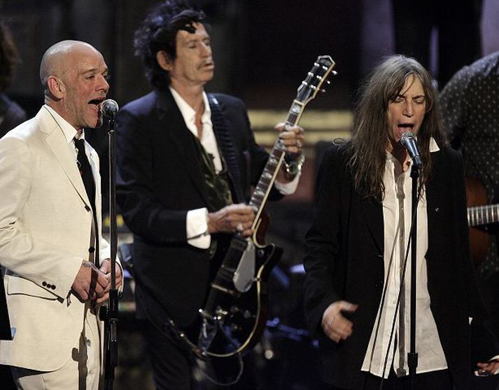 Michael Stipe og Patti Smith syngja við athöfnina í New York. Keith Richards er í bakgrunninum.