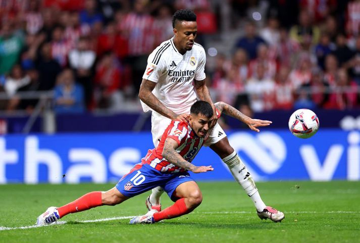 Angel Correa nær hér að jafna metin í baráttu við Eder Militao sem hafði komið Real Madrid yfir.