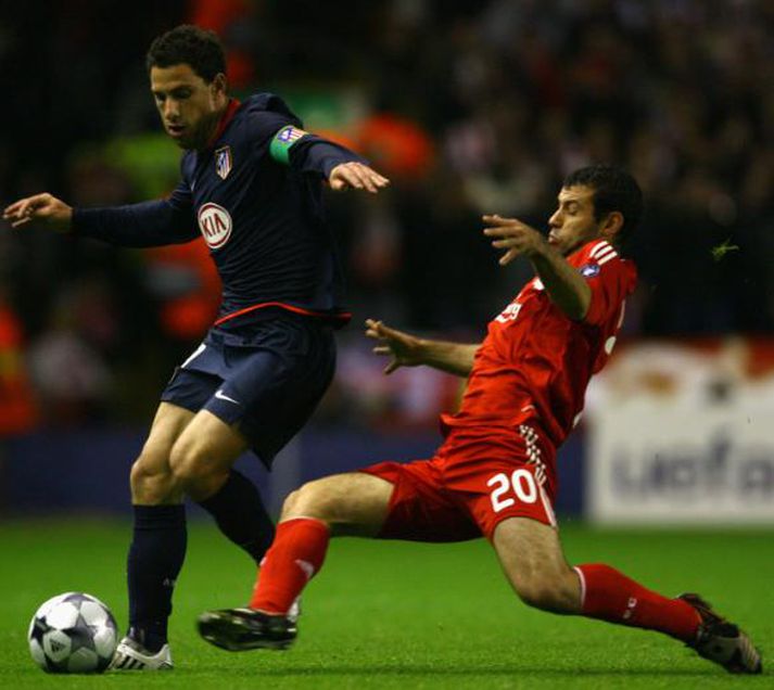 Maxi Rodriguez, markaskorari Atletico Madrid, í baráttunni gegn Javier Mascherano.