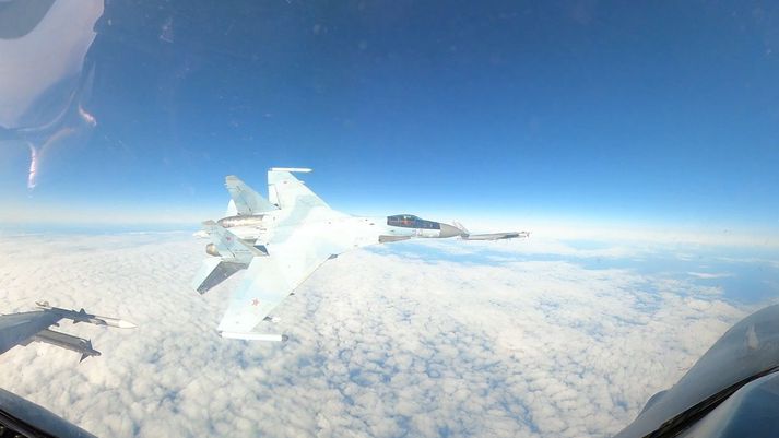 Rússnesk orrustuþota af gerðinni Su-35 og Tu-95 sprengjuflugvél er hér í bakgrunni.