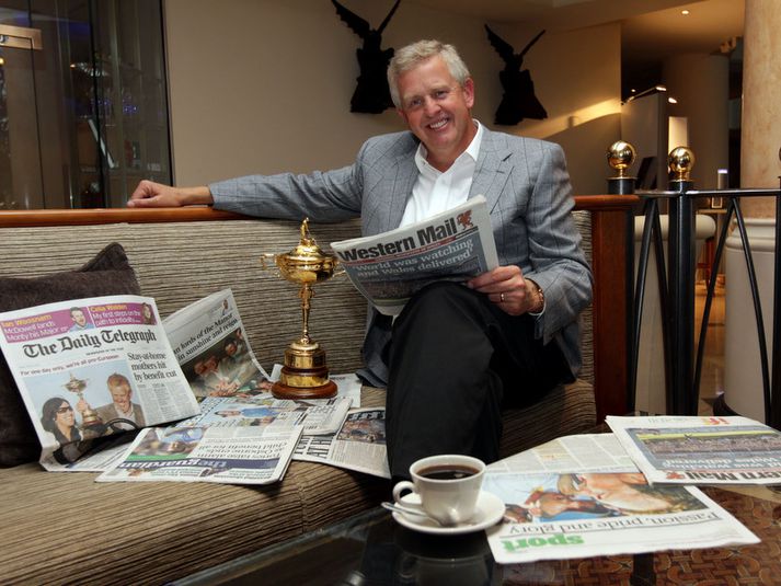 Colin Montgomerie skoðar blöðin eftir sigurinn. Ryder-bikarinn er við hlið hans.