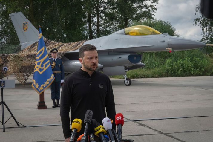 Vólódímír Selenskí Úkraínuforseti stendur hér við F-16 þotu.