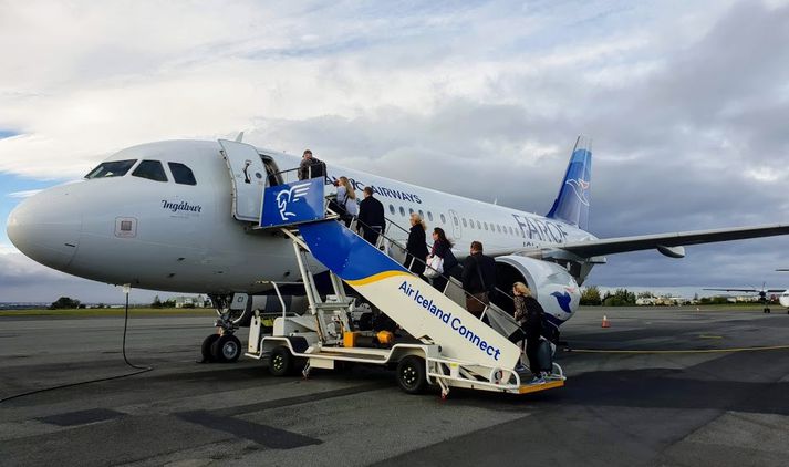 Farþegar á leið til Færeyja ganga um borð í Airbus A319 þotu Atlantic Airways á Reykjavíkurflugvelli í morgun.
