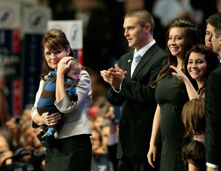 Sarah Palin heldur hér á syni sínum Trig. Track Palin stendur næstur við hlið þeirra.