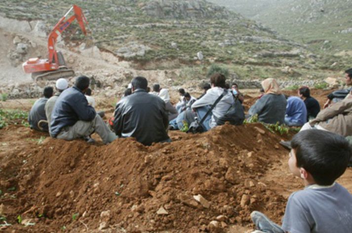 Palestínumenn og ísraelskir friðarsinnar fylgjast með ísraelskri jarðýtu sem vinnur að stækkun landnámabyggðarinnar í Efrat.