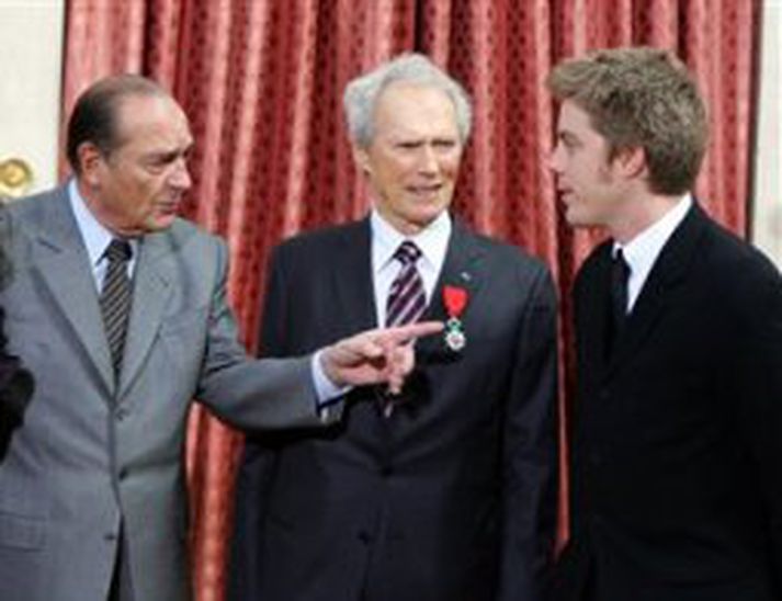 Clint Eastwood horfir á meðan Jacques Chirac forseti Frakklands og sonur hans Kyle tala saman.