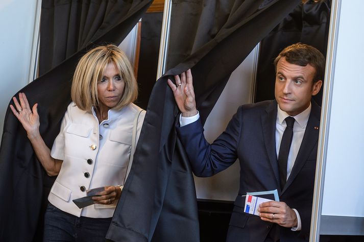 Emmanuel Macron, forseti Frakklands, á kjörstað í dag ásamt eiginkonu sinni Brigitte Macron.