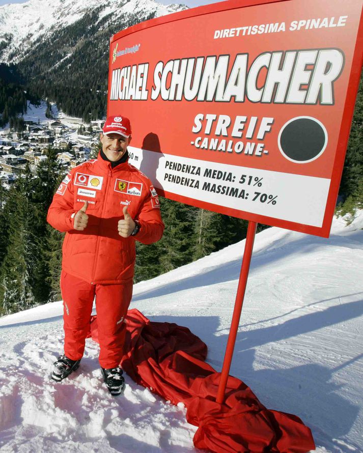 Michael Schumacher stendur stoltur viið samnefnda brunbrekku á skíðasvæði fína fólksins á Ítalíu.