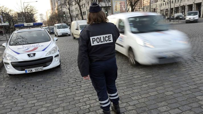 Lögreglumaður í París skoðar skráningarnúmer bíla.