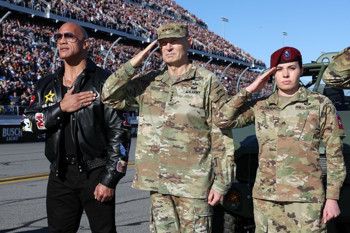 Dwayne „The Rock“ Johnson, eða Steini, ásamt hermönnum á NASCAR-opnunarhátíð. 12 milljarða auglýsingasamningur við NASCAR skilaði svo að segja engum nýskráningum í herinn.