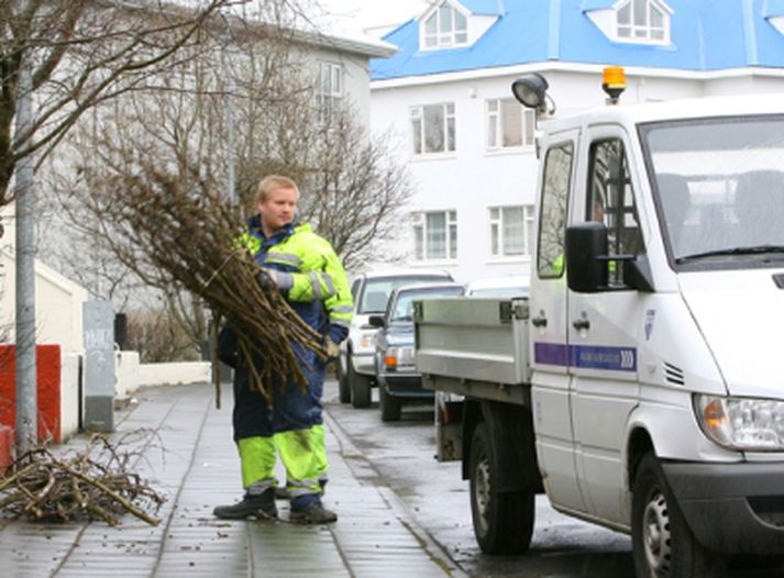 Starfsmaður borgarinnar fjarlægir greinar sem bundnar hafa verið saman.