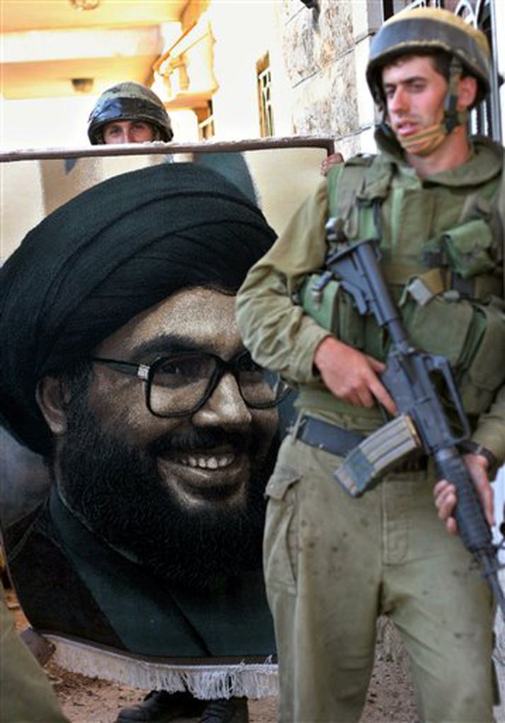 Ísraelskur hermaður við mynd af Sheik Hassan Nasrallah, leiðtoga Hizbollah